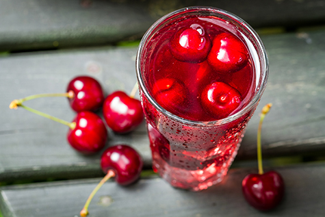 Closeup of fresh juice with sweet cherries and ice