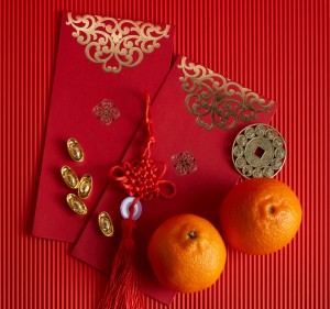 Chinese new year festival decorations. Orange, red packet, on red background.