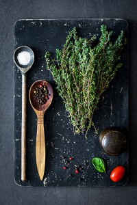 Thyme, sea salt, pepper and spices on cutting board