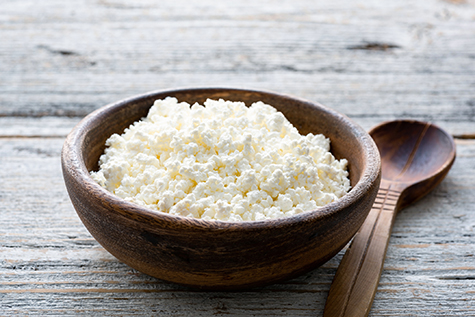 Ricotta cheese, cottage cheese farmers cheese, curd or tvorog in a wooden bowl