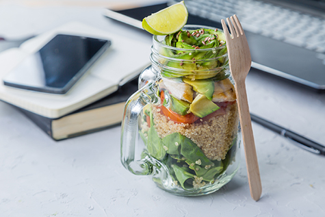 Healthy lunch in glass jar in workspace
