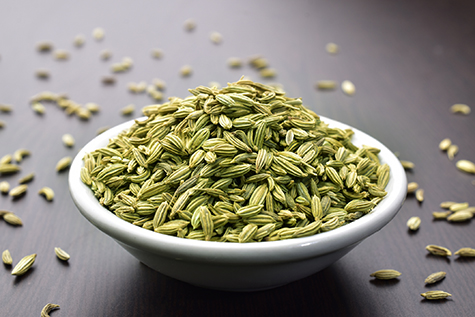 Fennel seeds in a bowl on a wooden table