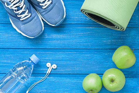Flat lay sport shoes, bottle of water, mat and earphones