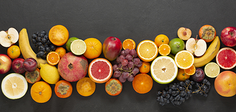 Strip of fruits on a black concrete background. An abundance of delicious healthy fruits.