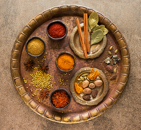 Selection Indian Spices and seasonings in bowls on a metal tray, top view