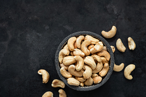 Cashew nuts in bowl on black background