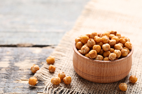 Roasted chickpeas in bowl on gray wooden table