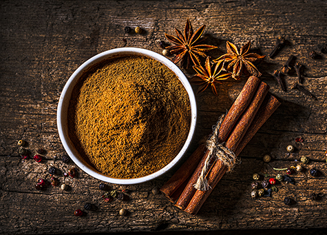Scented spices background: Cinnamon powder, cinnamon sticks, star anise and cloves