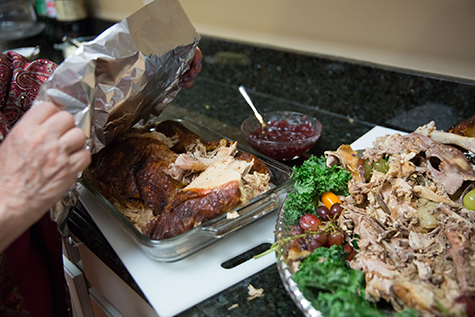 Woman wraps up leftover turkey from Thanksgiving dinner