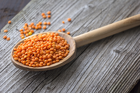 Red lentils on wooden spoon