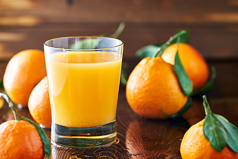 fresh glass of orange juice on rustic table top