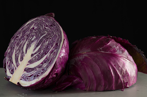 Purple cabbage sliced in half on silver table