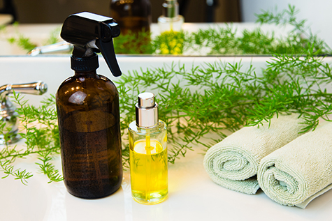 Spray bottles, towels and greens on bathroom countertop