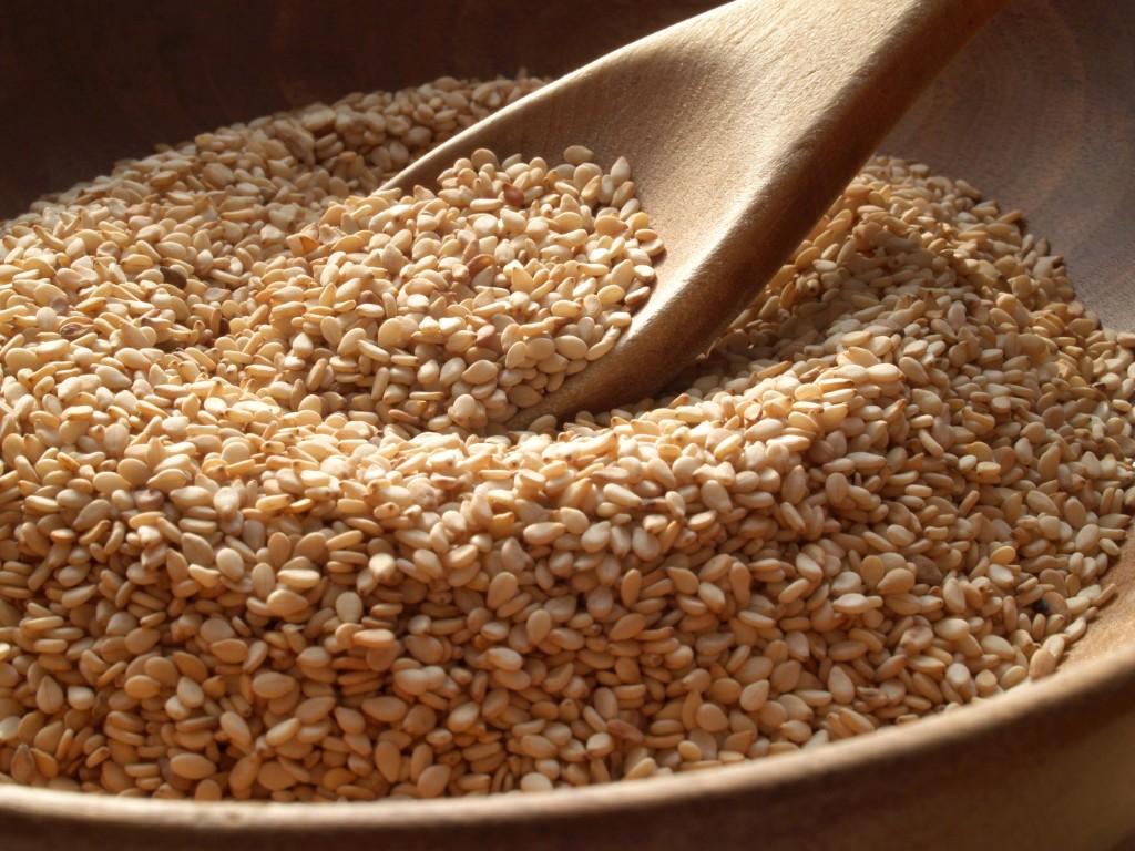 Close-up of a wooden spoon and bowl containing sesame seeds