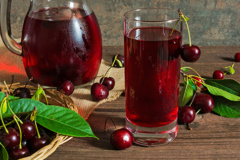 cherry juice in a glass and pitcher with cherries inside