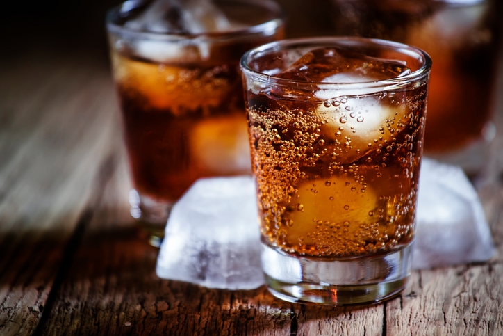 Alcoholic cocktail with cola and whiskey and ice cubes