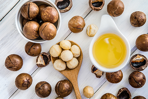 Macadamia Nut Oil and peeled macadamia nut on white table ,?use for Healthy Skin and Hair and Natural Healing Oil Treatment , overhead and top view