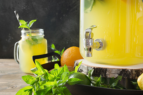 Lemonade with orange, citric , and mint cocktail in mason jar with mint on black stone table. Copy space for text.