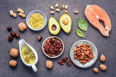 Selection food sources of omega 3 and unsaturated fats. Superfood high vitamin e and dietary fiber for healthy food. Almond ,pecan,hazelnuts,walnuts,olive oil,fish oil and salmon on stone background.